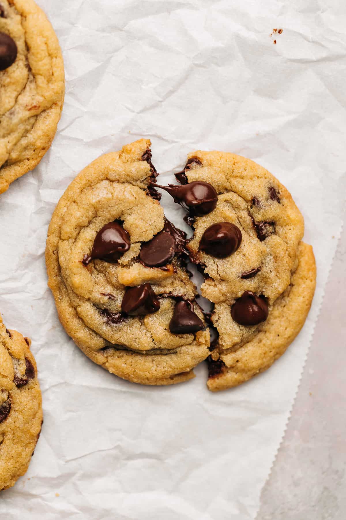 chocolate chip cookie cut in half on parchment paper.