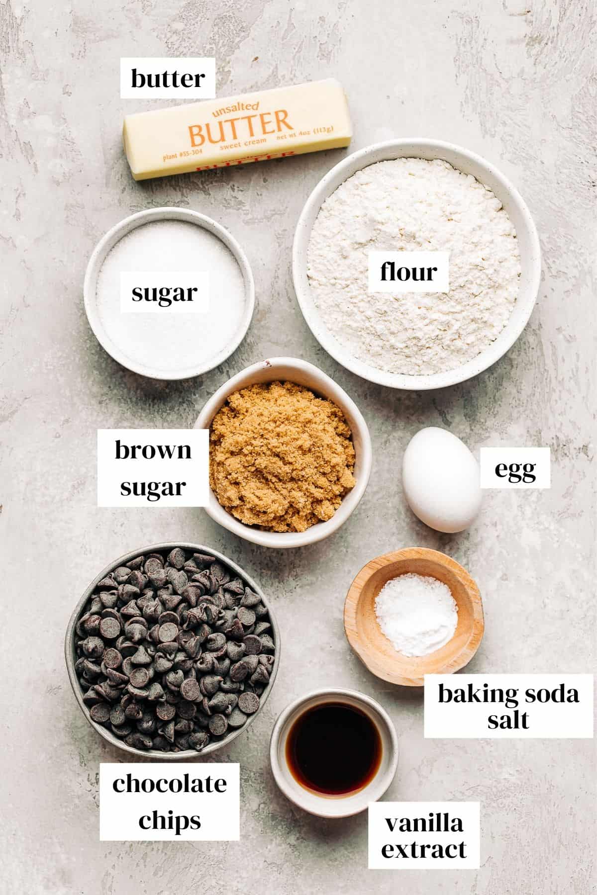 butter, flour, sugar, brown sugar, egg, chocolate chips, baking soda, salt, and vanilla extract in small bowls.