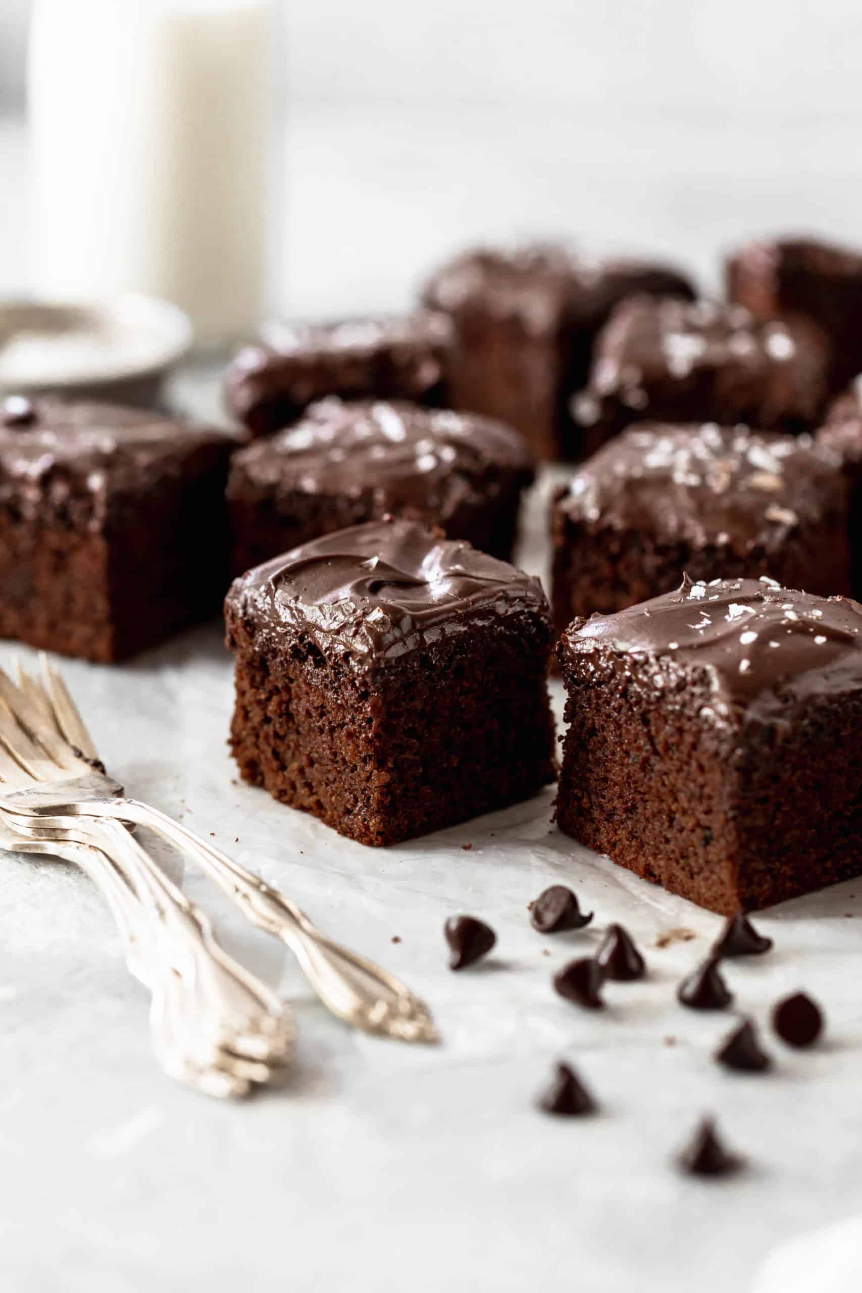 chocolate cake pieces with chocolate frosting on parchment paper