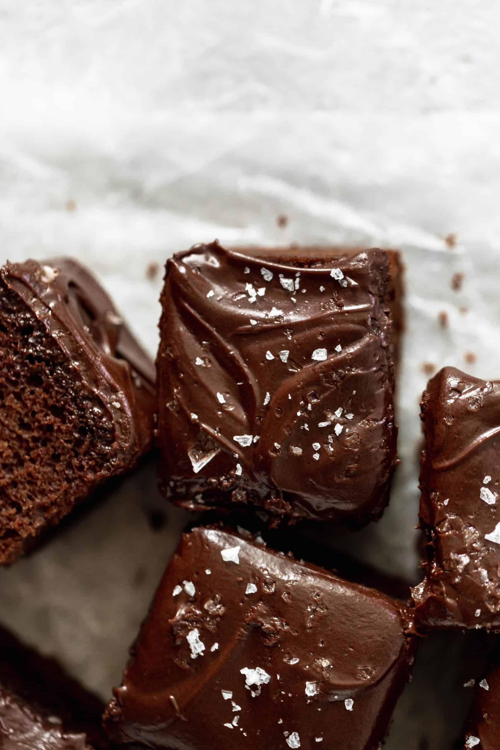 piece of chocolate cake with chocolate frosting and flaked sea salt