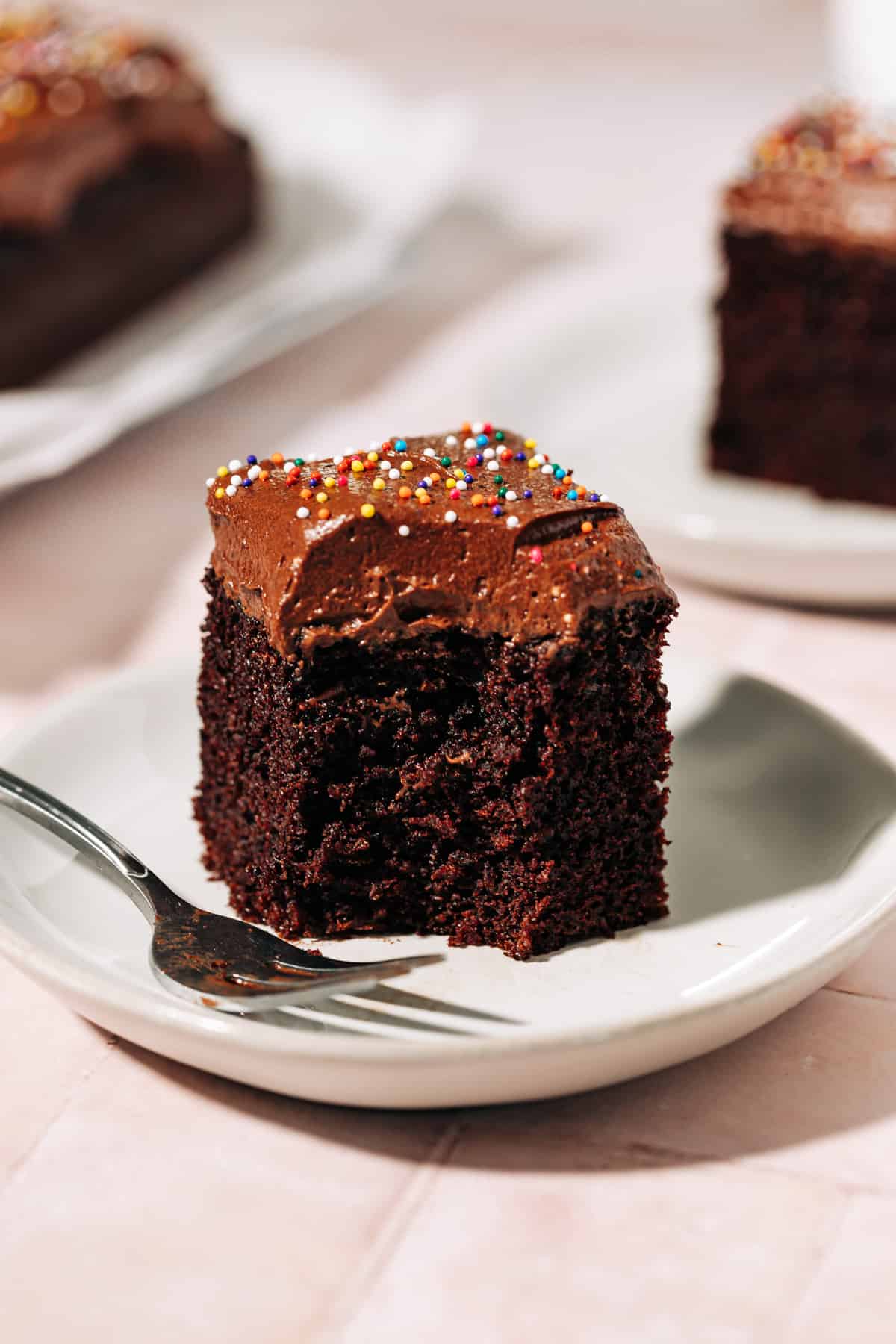 bite shot of a slice of chocolate cake topped with chocolate frosting.