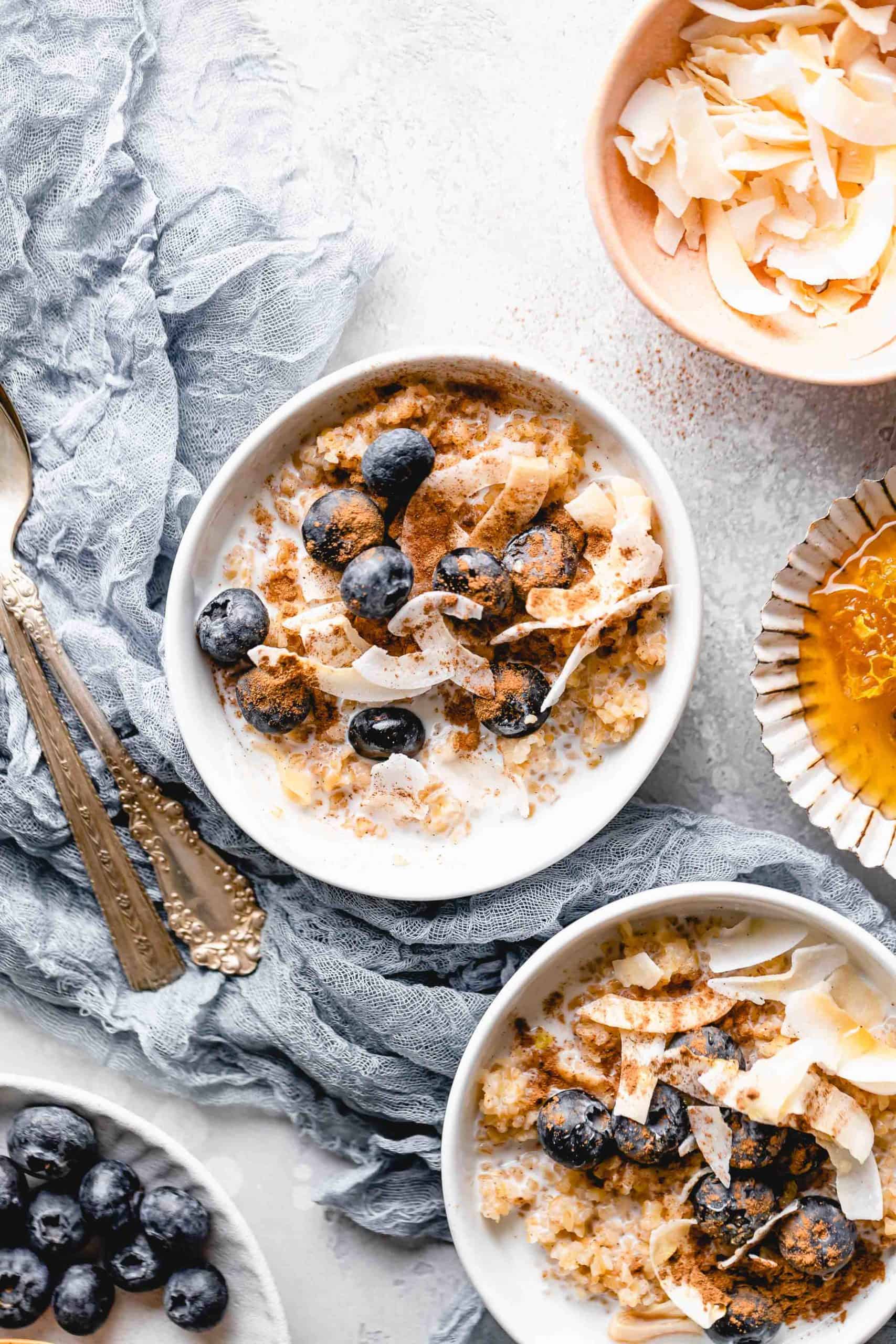 bulgur breakfast bowl topped with coconut flakes, blueberries, cinnamon, and honey