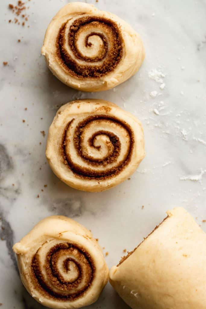 cut cinnamon rolls on a marble surface