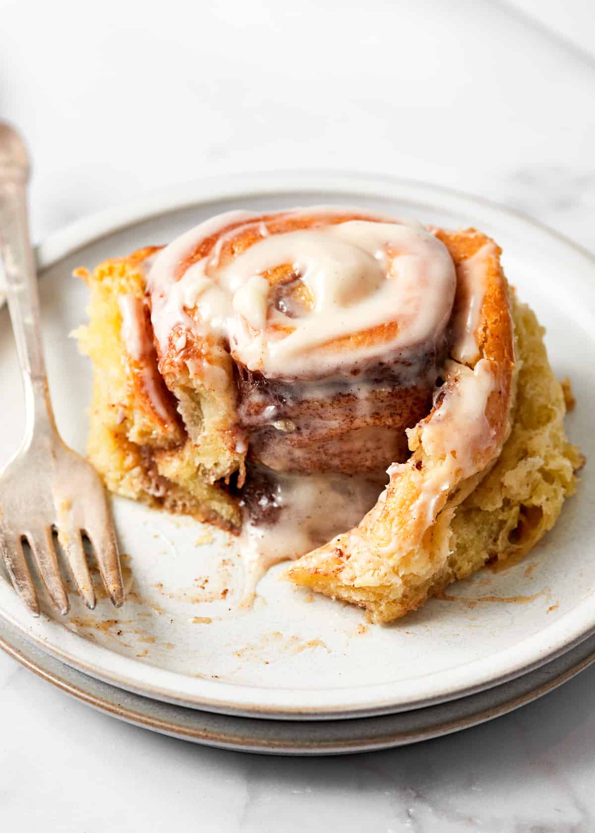 cinnamon roll with cream cheese icing on a plate.