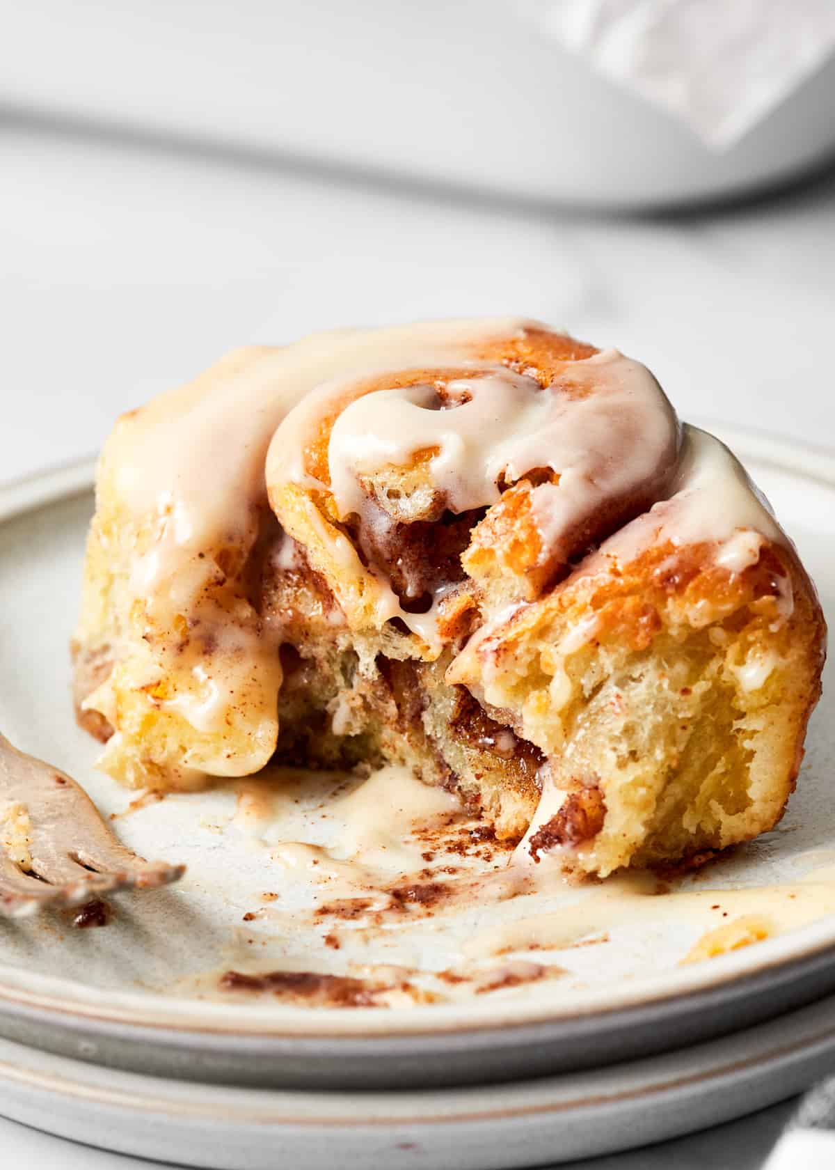 cinnamon roll with cream cheese icing on a plate.