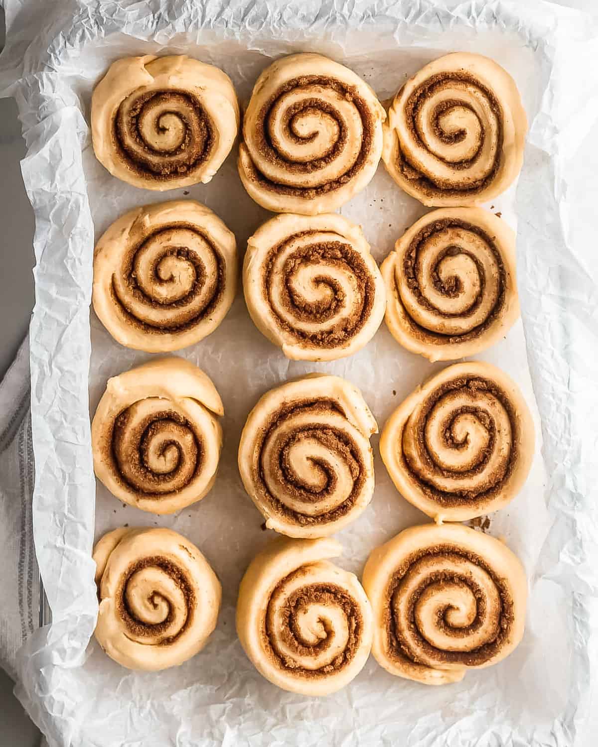 unbaked cinnamon rolls in a pan.