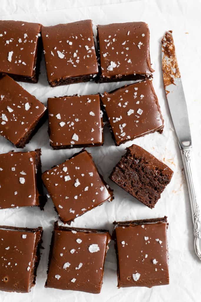 fudge brownies with ganache on parchment paper