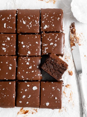 fudge brownies with ganache on parchment paper