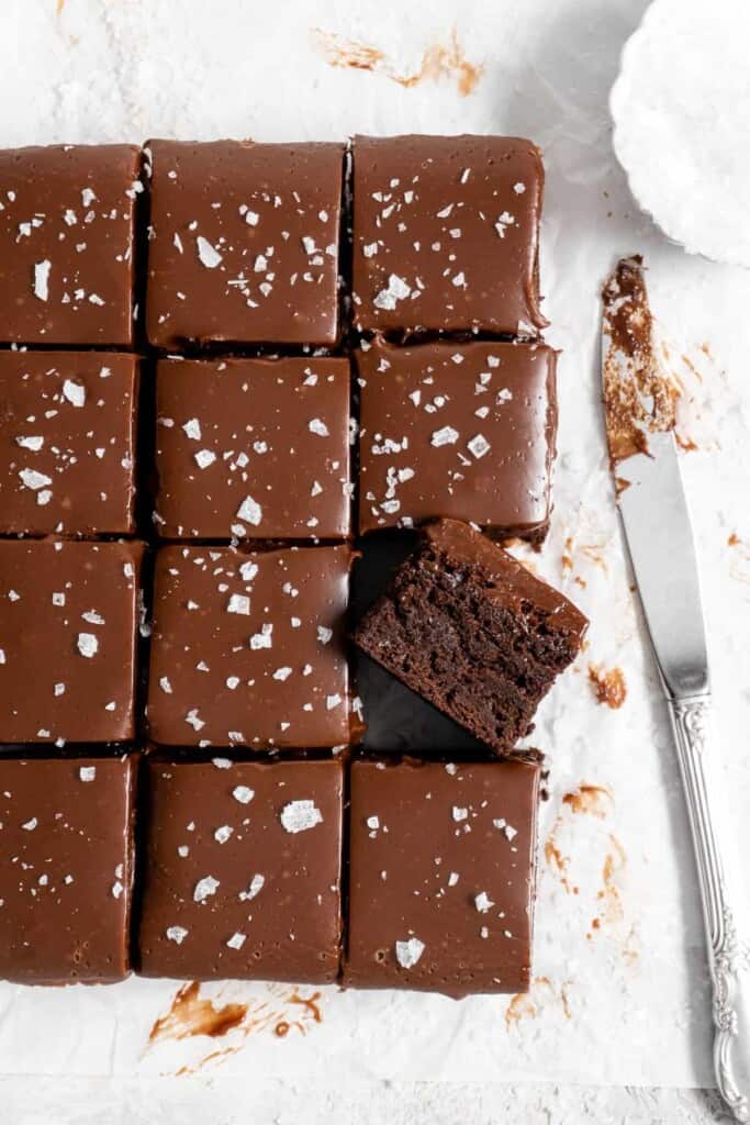 fudge brownies with ganache on parchment paper