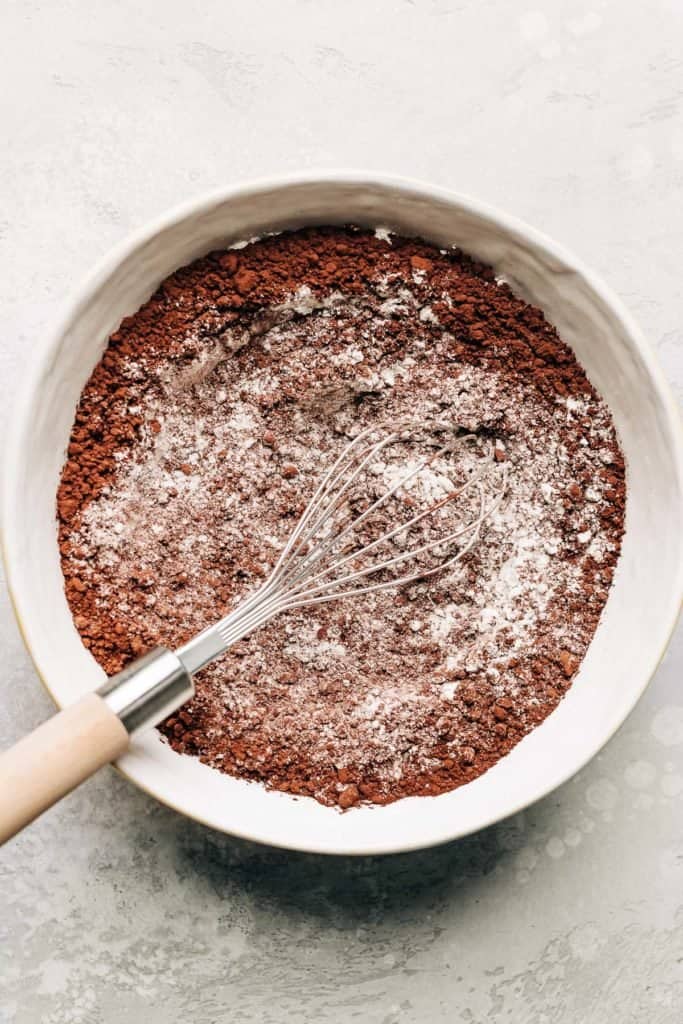 flour and cocoa powder in a bowl with a whisk