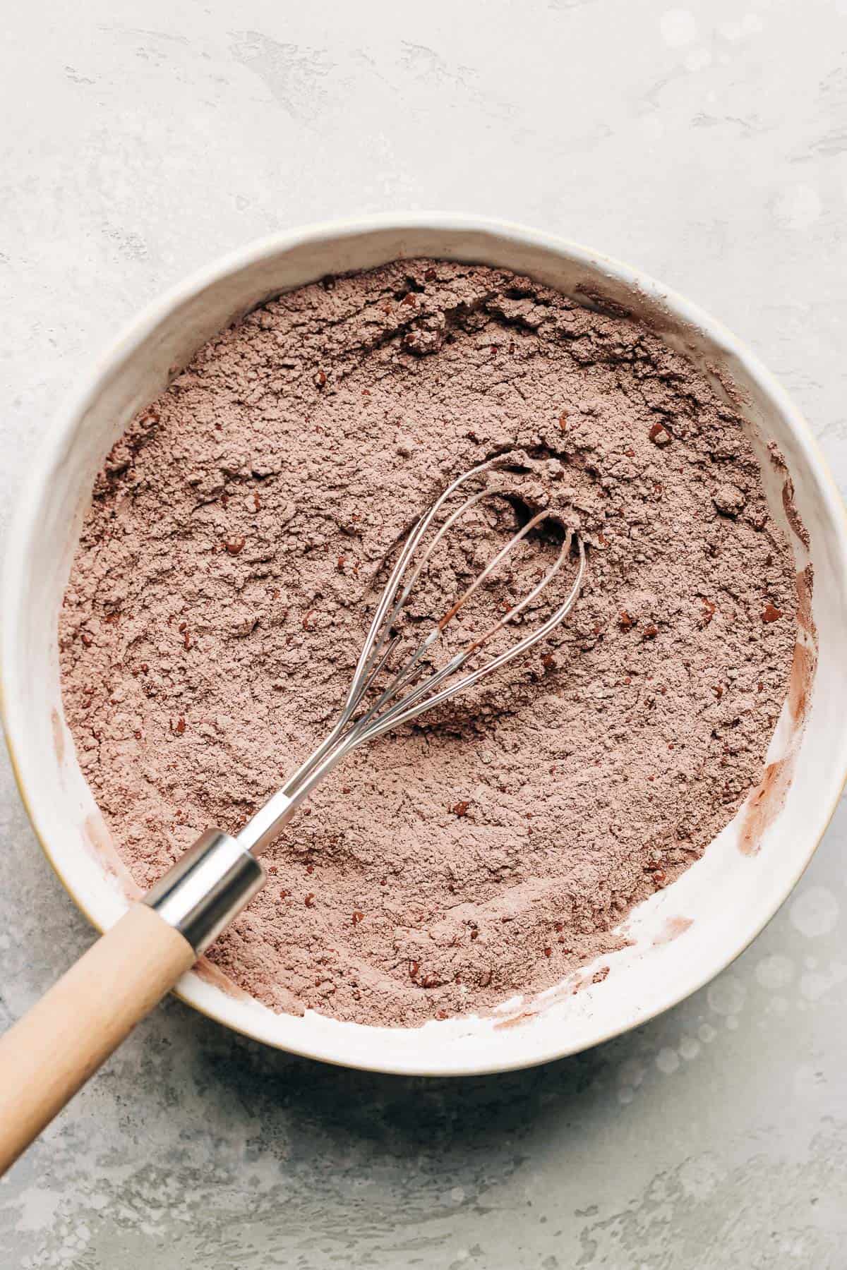 flour and cocoa powder in a bowl with a whisk