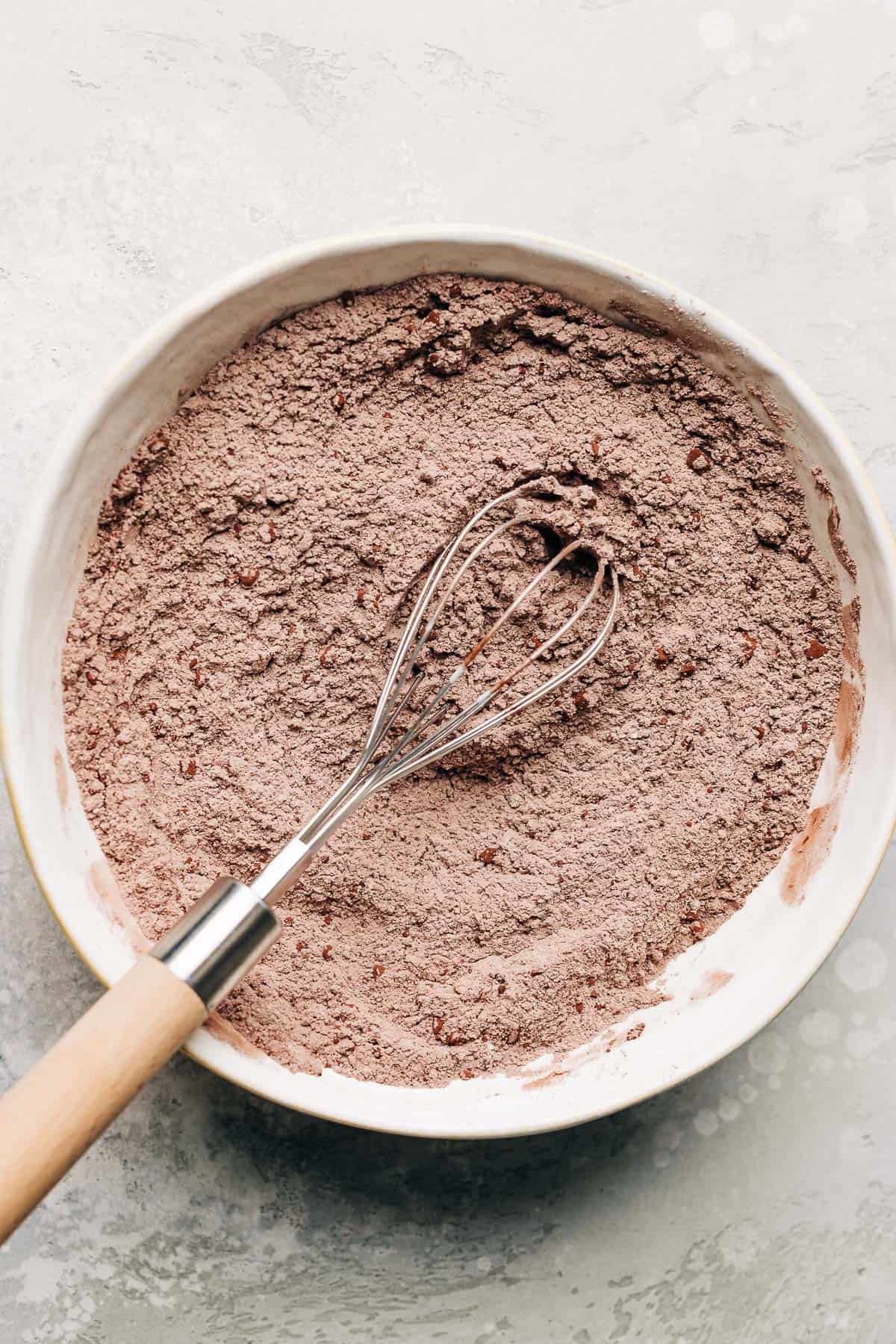 flour and cocoa powder in a bowl with a whisk