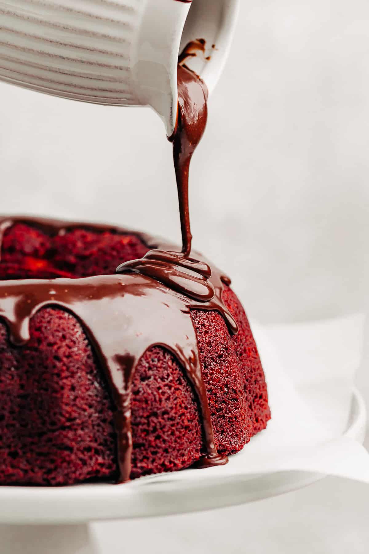 nutella glaze being poured over a Red Velvet Bundt Cake.