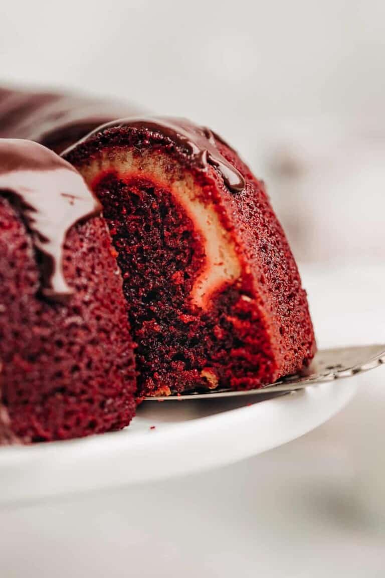 slice of Red Velvet Cream Cheese Bundt Cake on a cake stand.