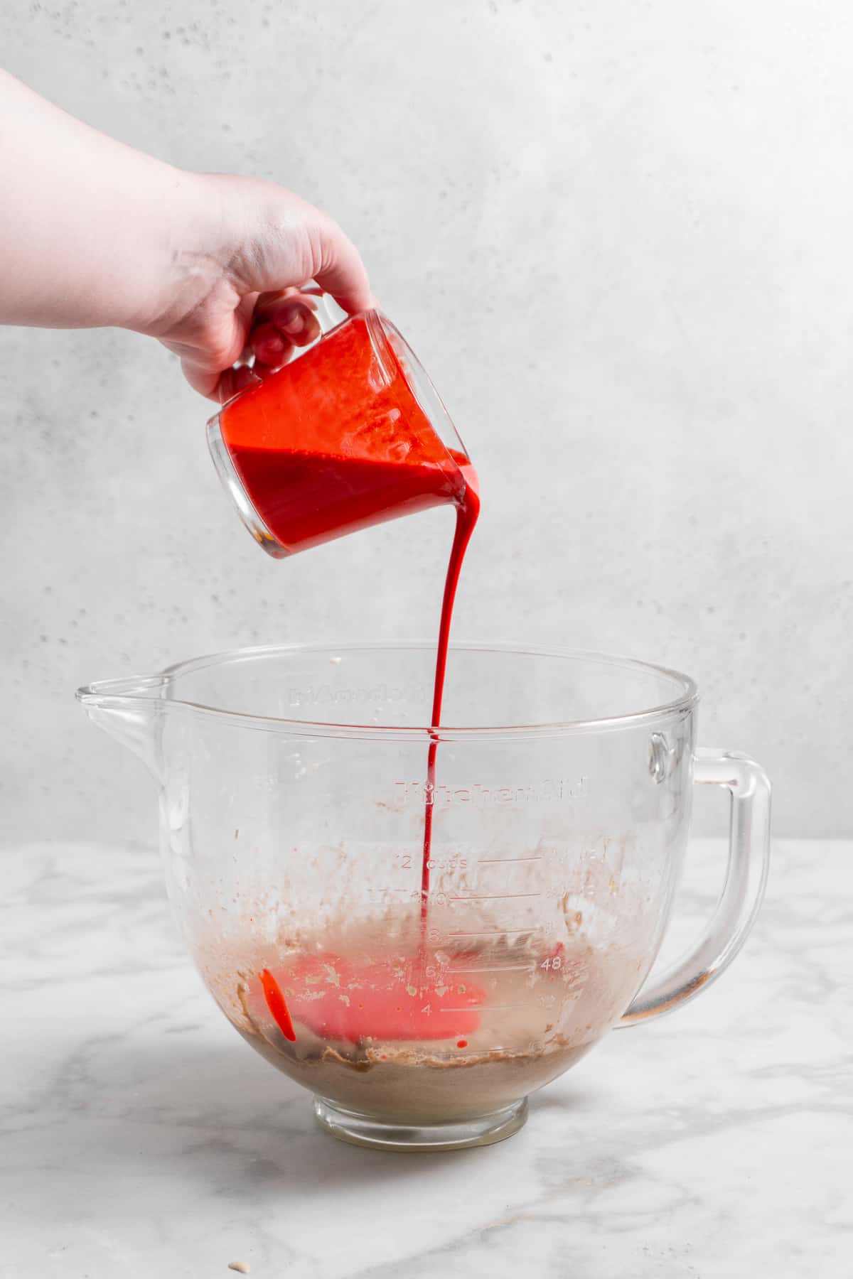red velvet cupcake batter in a glass mixing bowl.