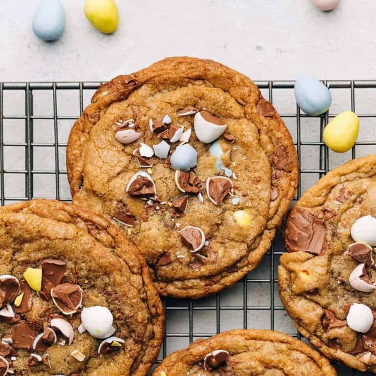 Cadbury Mini Egg chocolate chip cookies on a wire rack.