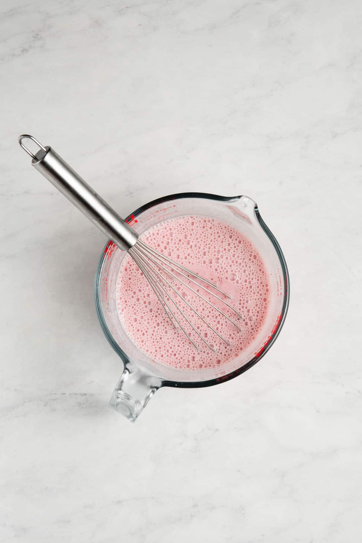 strawberry puree, egg whites, and buttermilk in a glass measuring cup.