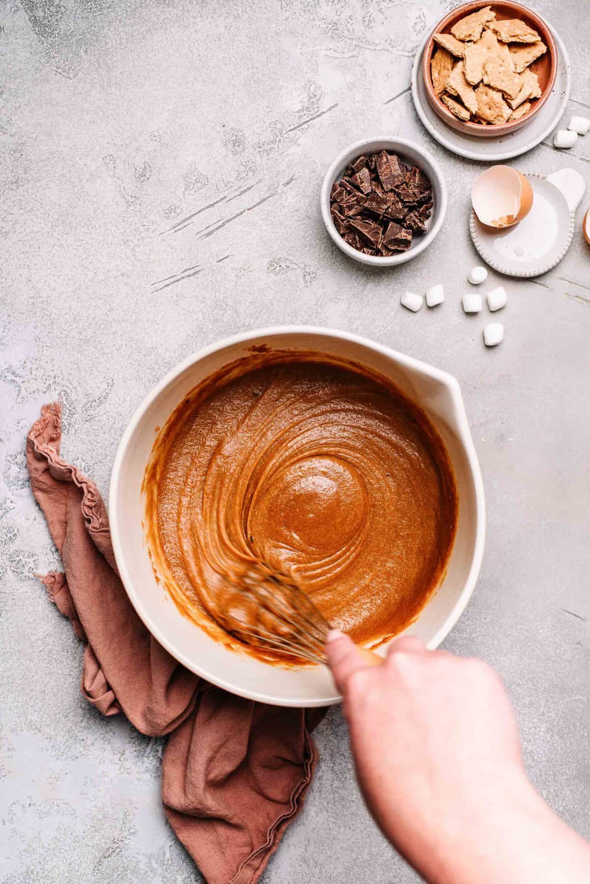 Melted butter, brown sugar, sugar, and eggs whisked together in a mixing bowl.