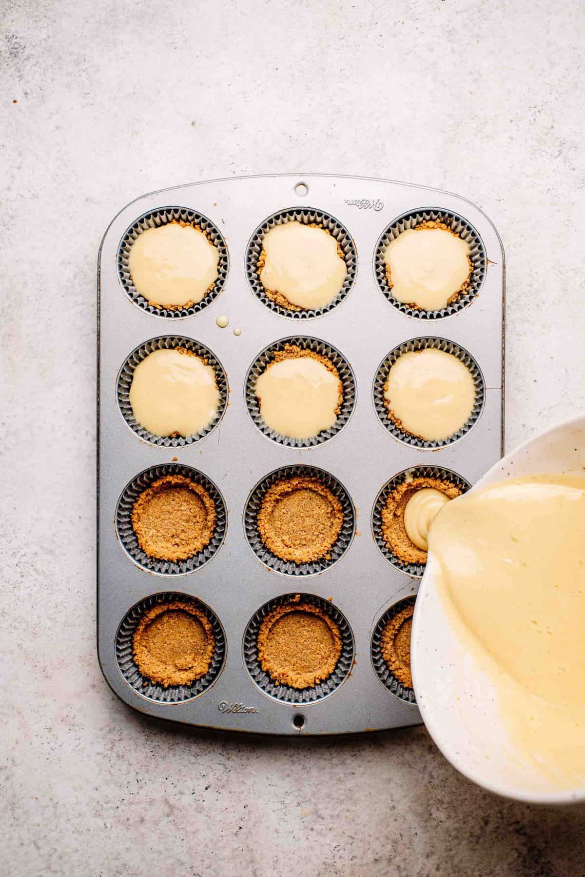 Key lime pie filling poured into mini graham cracker crusts.