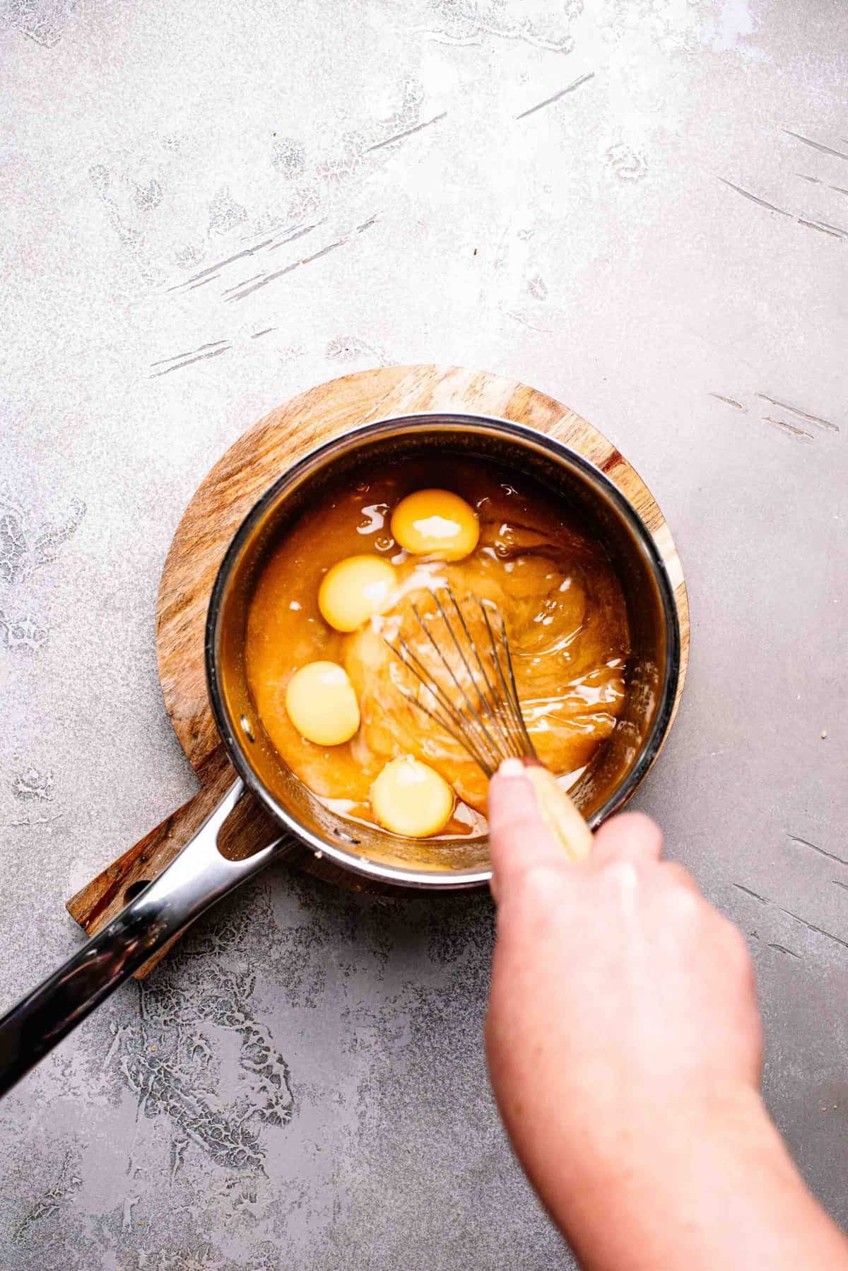 Eggs whisked in a saucepan.