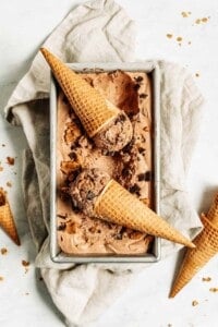 Chocolate peanut butter ice cream in a pan with two cones.