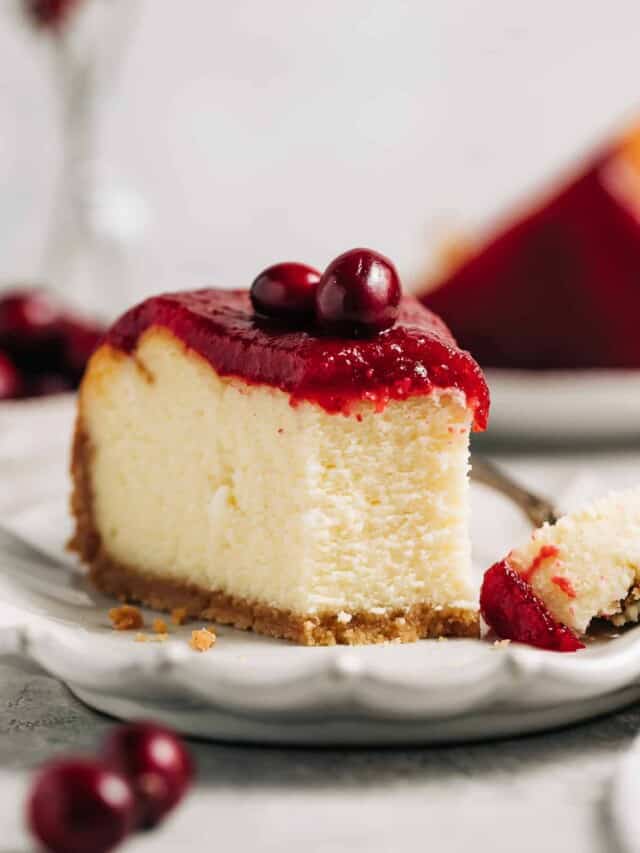 slice of white chocolate cranberry cheesecake on a plate.