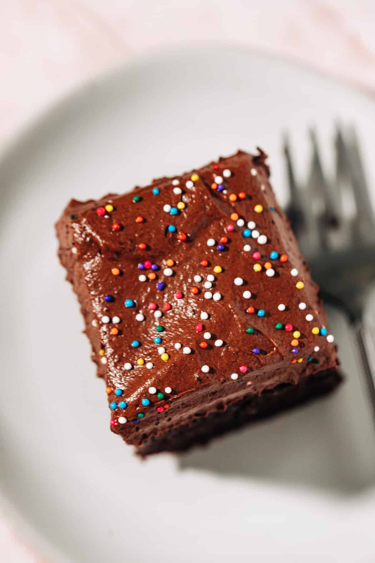 chocolate frosting with sprinkles on a cake.