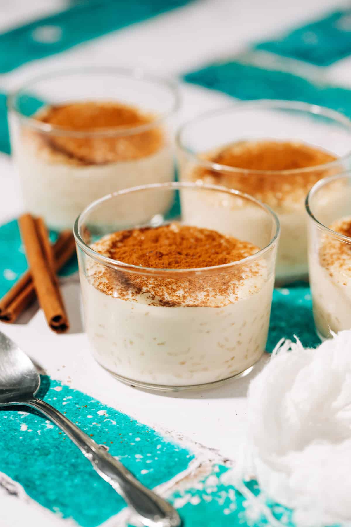 three small bowls of rizogalo topped with cinnamon.