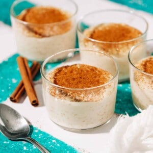 three small bowls of rizogalo topped with cinnamon.