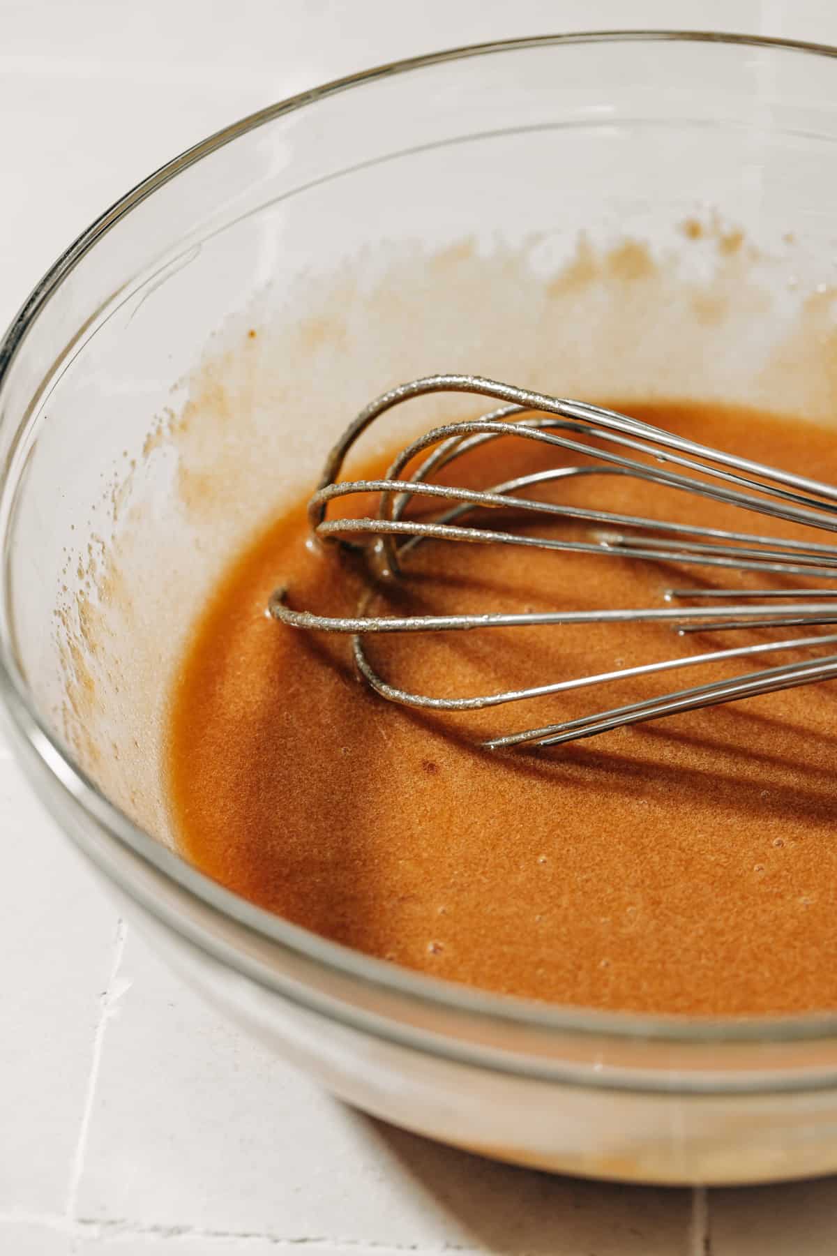 melted butter, brown sugar, and an egg in a mixing bowl.