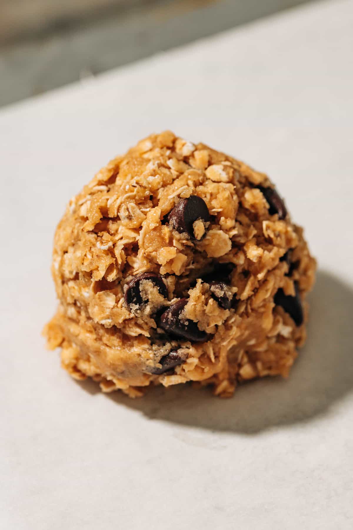 unbaked oatmeal chocolate chip cookie on a baking sheet.