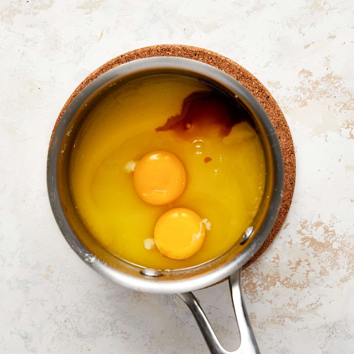 eggs and vanilla in saucepan with butter and sugar mixture.