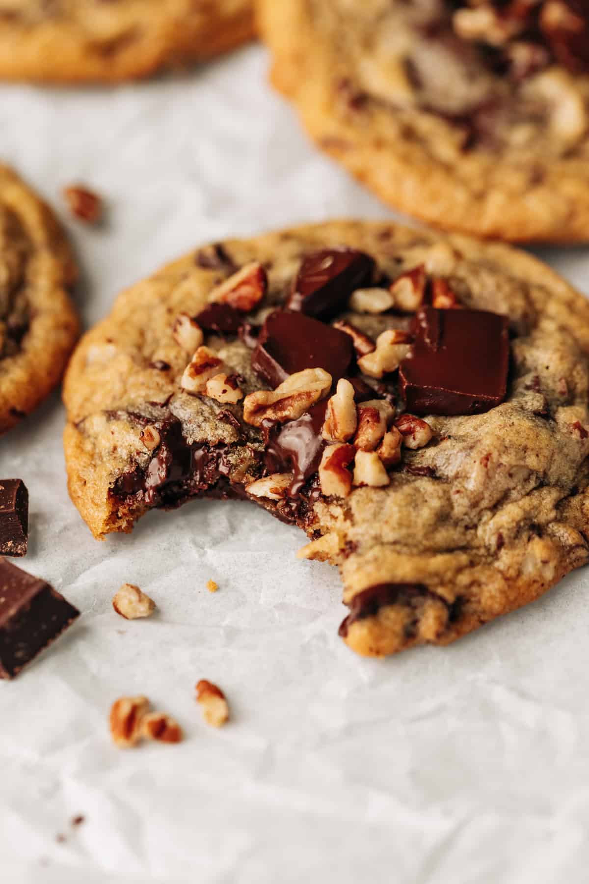 chocolate chip pecan cookie with a bite taken out of it.