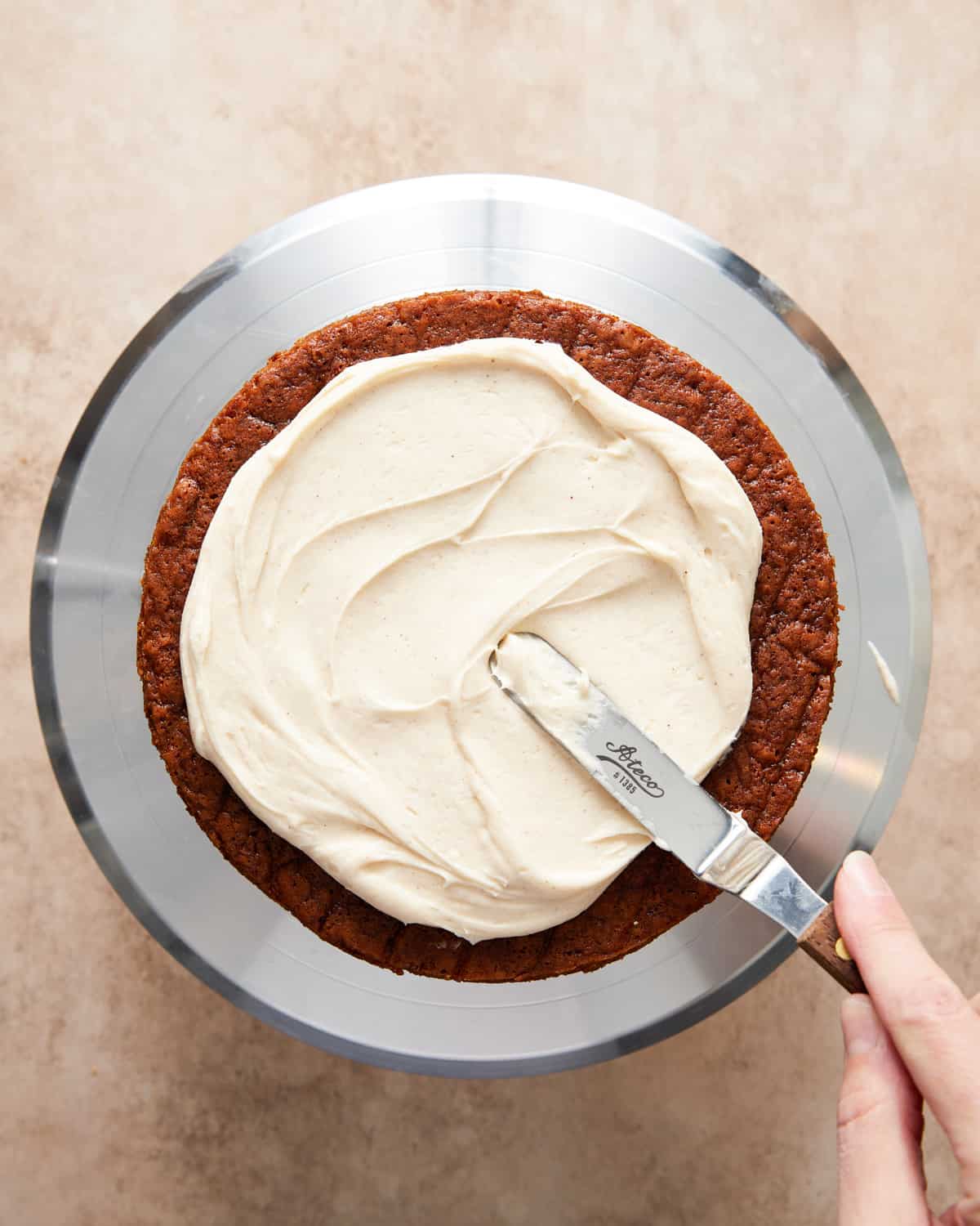 assembling gingerbread layer cake with cream cheese frosting.