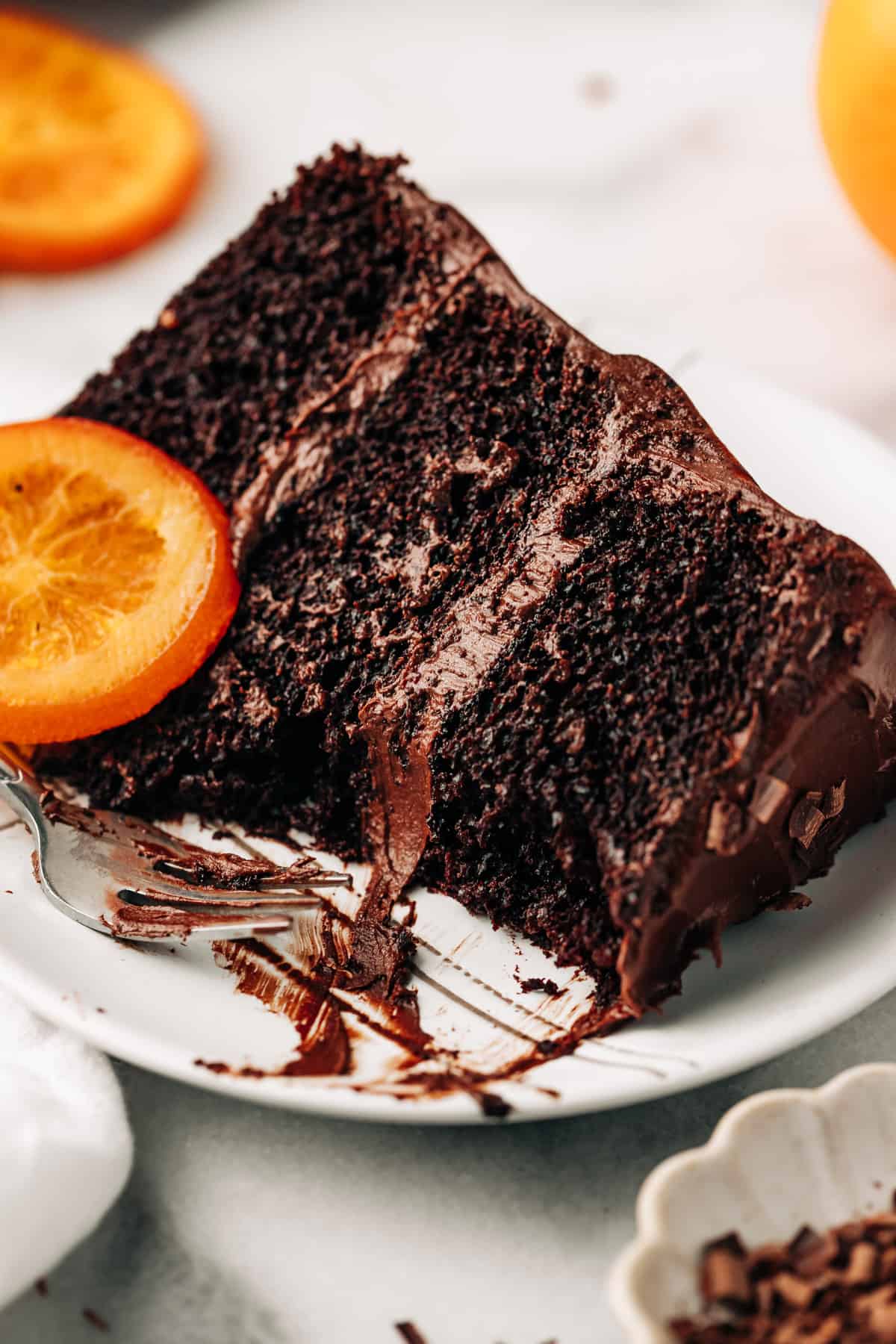 a slice of moist chocolate orange layer cake on a plate.