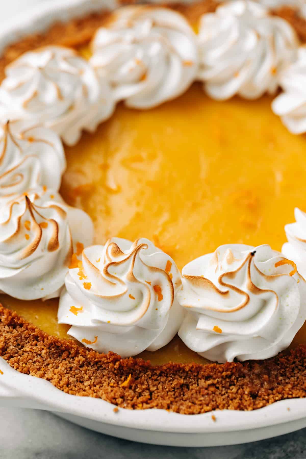 toasted meringue on top of an orange pie.