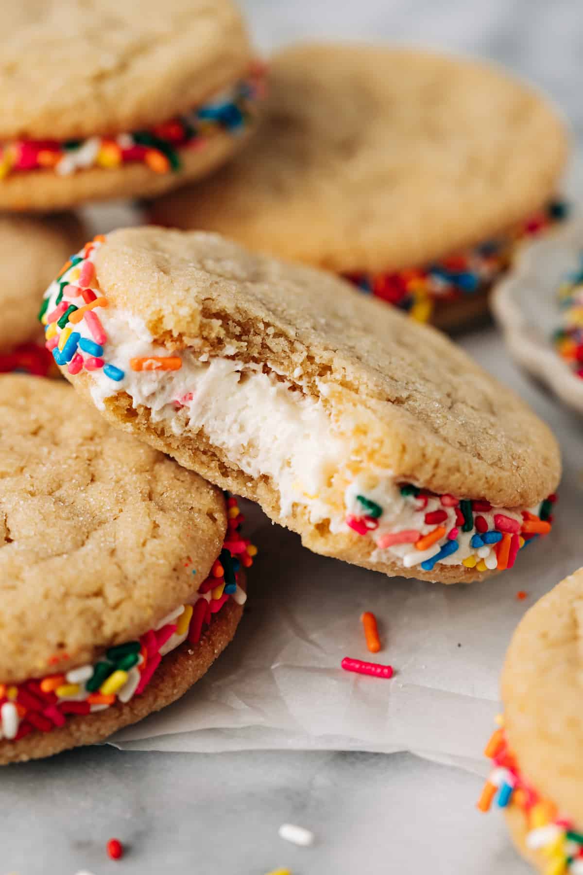 bite shot of a sugar cookie sandwich stuffed with buttercream frosting.
