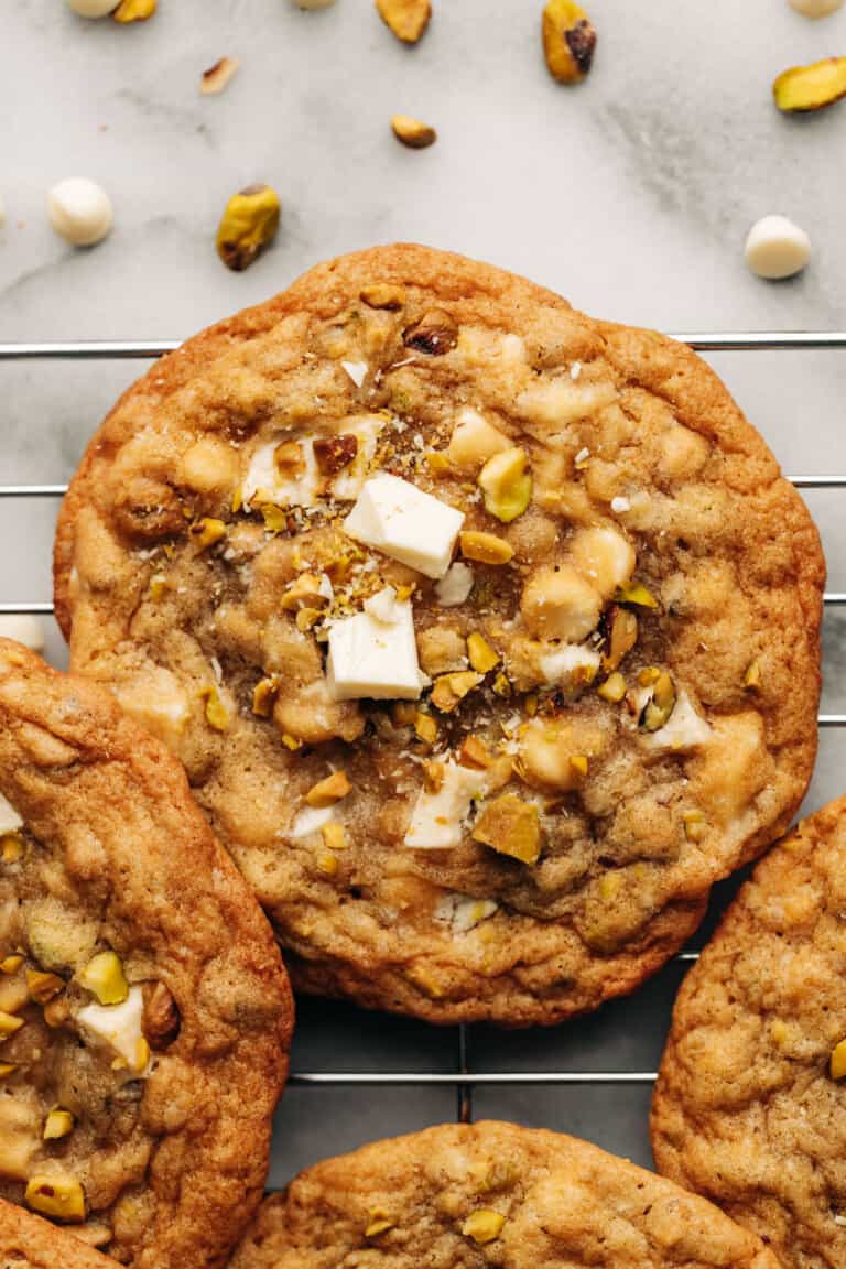 pistachio white chocolate cookie on a wire rack.